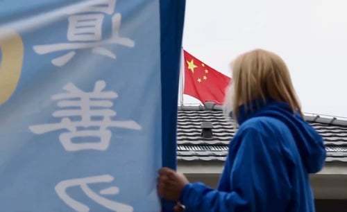 Српскa практикантка на Фалун Гонг држи транспарент пред кинеската амбасада во Белград (Minghui.org, 2019.)