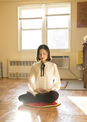Ли Фујао ја демонстрира својата медитативна пракса во својата куќа во Квинс, Њујорк, на 8. јануари 2016 година. Таа и нејзините родители побегнаа од Кина во 2014 година и добија азил по повеќе години мачење заради вежбање на Фалун Гонг. (Самира Буау / Епох Тајмс)
